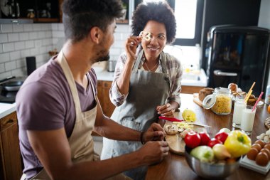 Mutfakta eğleniyorum. Güzel, genç bir çift evde birlikte sağlıklı yemekler pişiriyor.