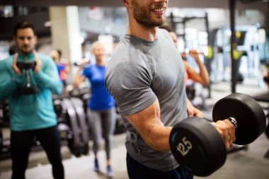 Spor salonunda egzersiz yapan bir grup genç arkadaş.