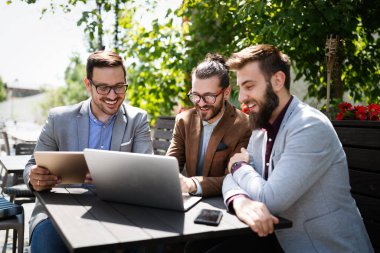Dışarıda iş görüşmesi. Bir grup çekici genç iş adamı Kafe 'de birlikte çalışıyorlar.