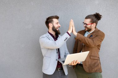 Toplantıda dijital cihazlar kullanan mutlu genç iş adamlarının portresi
