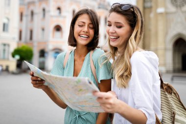 Group of happy traveling tourists sightseeing with map and having fun clipart
