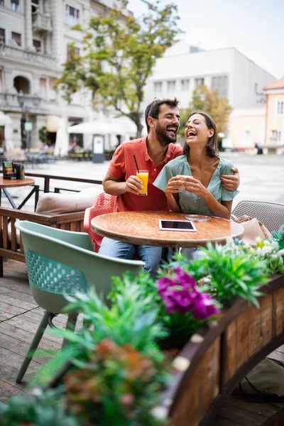 Mutlu çift kahve içiyor ve yaz tatilinde açık hava kafesinde eğleniyor.