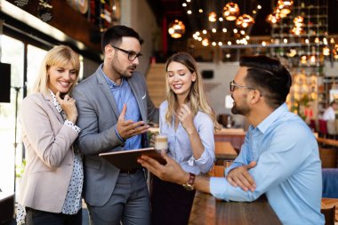 Genç iş adamları işyerinde eğleniyor ve sohbet ediyorlar.