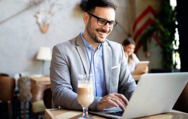Kafede dizüstü bilgisayarın önünde oturan başarılı bir girişimcinin portresi..