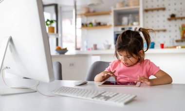 Evde teknoloji aletleriyle oynayan küçük bağımlı çocuk..