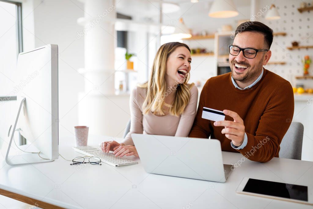 Portrait of a cheerful couple in love shopping online. Technology, e-commerce, banking concept