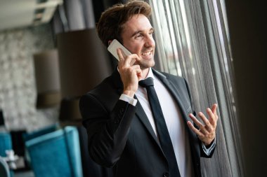 Akıllı telefon kullanan başarılı genç bir iş adamı.