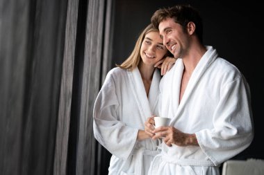 Modern bir otelde balayı yapan bornozlu bir çift.