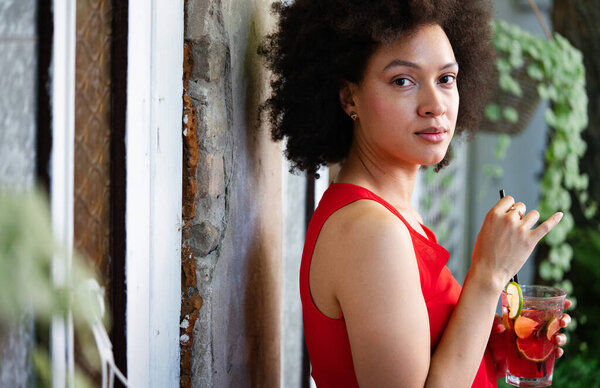 Fashion portrait of sexy pretty african woman with drink outdoor