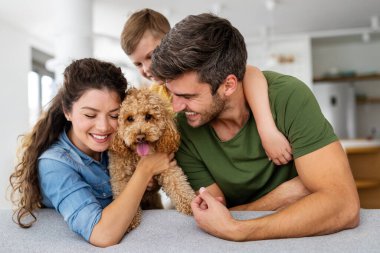 Mutlu genç aile eğleniyor, evde birlikte oynuyorlar. Mutlu çocukluk kavramı