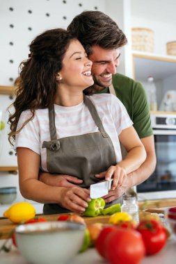 Mutlu genç çift evde yemek hazırlıyor. Sağlıklı yemek, insanların kavramı.