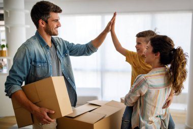 Aile yeni evinde karton kutuları açıyor. Yeni ev, aile, sigorta konsepti.