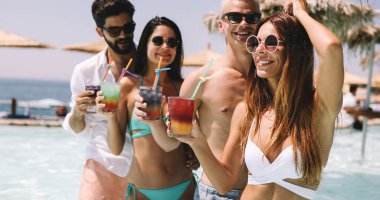 Bir grup mutlu arkadaş tropik sahilde eğleniyor, yaz tatili partisinde.