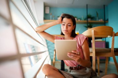 Güzel öğrenci ya da iş kadınının portresi dijital tablet kullanarak günlük kıyafetle.