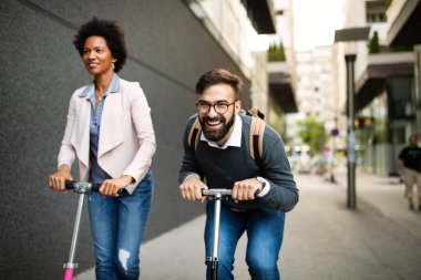 Genç çift şehirde elektrikli scooter sürerken eğleniyor..