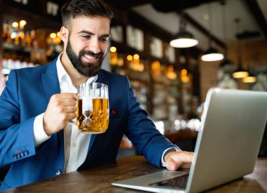 Restorandaki iş molasında dizüstü bilgisayar kullanan yakışıklı bir iş adamı.