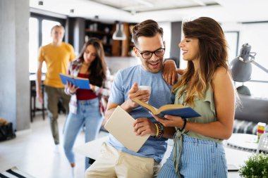 Grup çalışmasından hoşlanan bir grup genç. Projeleri için bilgi toplayan kitap ve dizüstü bilgisayarı olan mutlu üniversite öğrencileri.