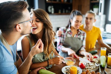 Mutfakta yemek pişirirken gülen ve konuşan iyi arkadaşlar.