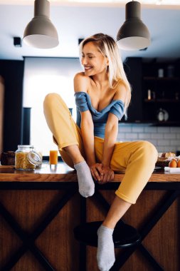 Evde uzun sarı saçlı, güzel, şehvetli bir kadının portresi.