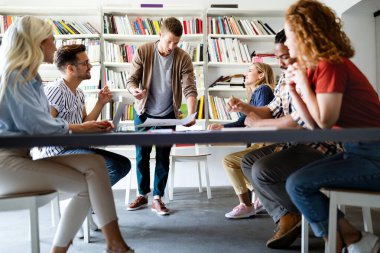 Genç mimar meslektaşları ofiste yeni bir proje üzerinde çalışırken projeleri analiz ediyorlar..