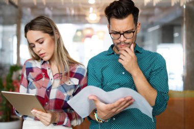 Genç mimar meslektaşları ofiste yeni bir proje üzerinde çalışırken projeleri analiz ediyorlar..
