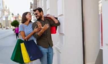 Birlikte alışveriş yapmayı seviyoruz. Güzel, genç bir çift alışveriş yaparken ve seyahat ederken sokakta yürüyor.