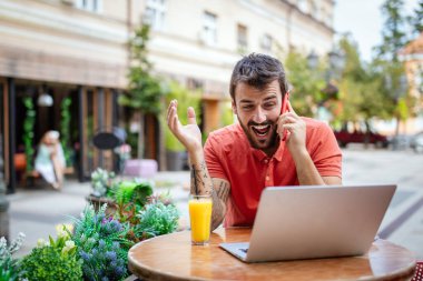 Laptoplu yakışıklı adam kafede boş zamanlarının tadını çıkarıyor.