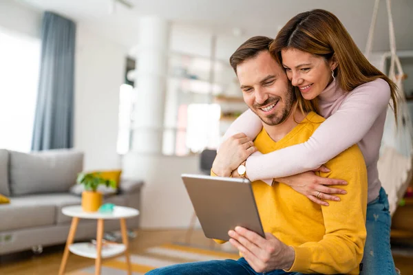 Pareja Enamorada Abrazando Usando Tableta Juntos Casa — Foto de Stock