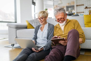 Mutlu son sınıf çifti teknoloji aletleri kullanıyor ve evde eğleniyor.