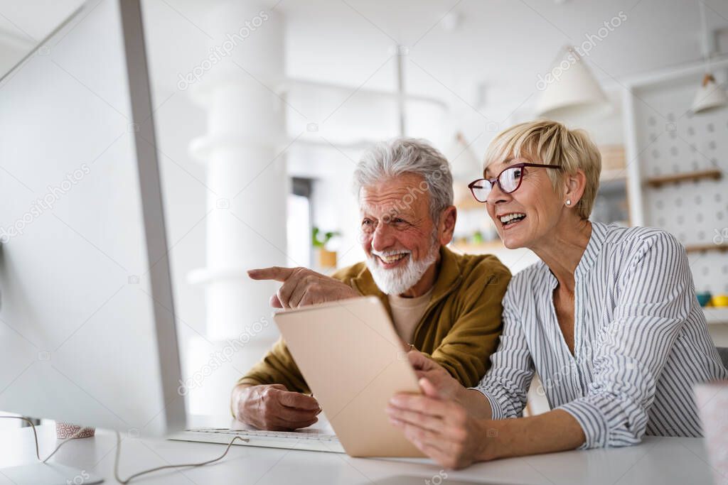 Senior woman helping senior man to use computer. Technology people concept