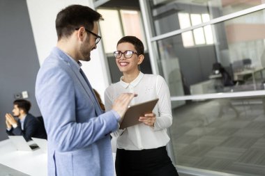 Mutlu iş adamları iş yerinde eğleniyor ve sohbet ediyorlar.