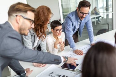 İş arkadaşları modern ofiste yeni fikirleri tartışıyor ve beyin fırtınası yapıyorlar.