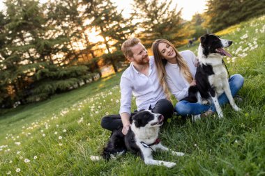 Romantik mutlu çift dışarıda evcil hayvanlarla eğleniyor.