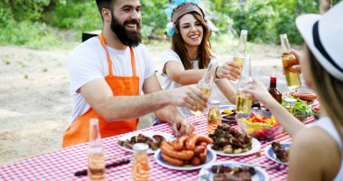Bir grup arkadaş dışarıda barbekü partisi veriyor ve birlikte eğleniyorlar.