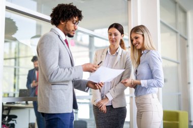 Çeşitli iş arkadaşları modern ofiste iş projesinde birlikte çalışıyorlar.