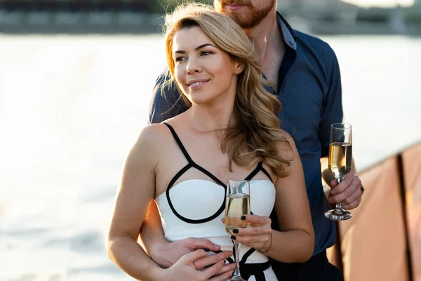 一对快乐的年轻夫妇在船上谈恋爱 喝香槟 — 图库照片