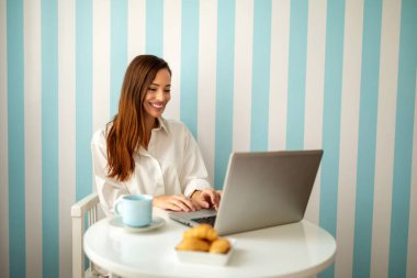 Genç bayan evde dinlendirici bir sabah geçiriyor. Çalışma, teknoloji, insanlar, tecrit kavramı.