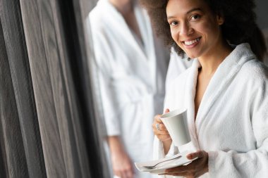 Sağlık haftasonu boyunca bornozlu Afrikalı kadın çay içiyor.