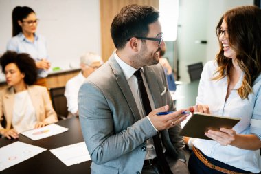Mutlu iş adamları işyerinde çalışıyor, eğleniyor ve sohbet ediyorlar.