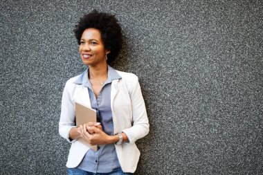 Şehirde dijital tabletli mutlu iş kadını