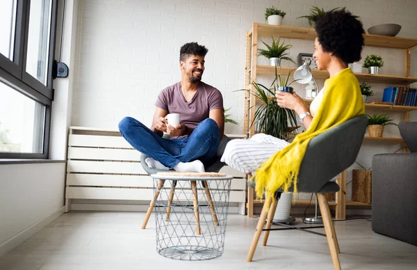 幸せなアフリカ系アメリカ人の夫婦が居心地の良い家でコーヒーを飲む ファミリーレジャー リラクゼーションコンセプト — ストック写真