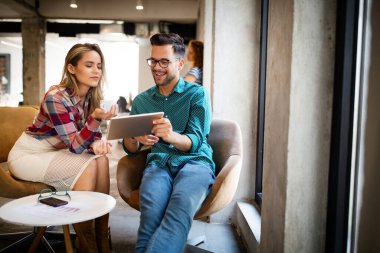 İş adamları, tasarımcılar işyerinde eğleniyor ve sohbet ediyorlar.
