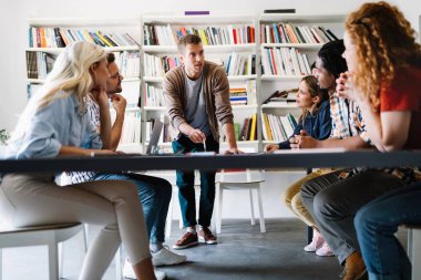 Genç mimar meslektaşları ofiste yeni bir proje üzerinde çalışırken projeleri analiz ediyorlar..