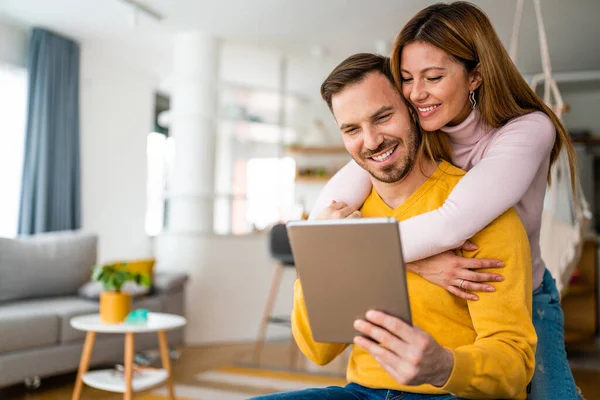 快乐快乐的年轻夫妇在家里用数码平板电脑恋爱 — 图库照片