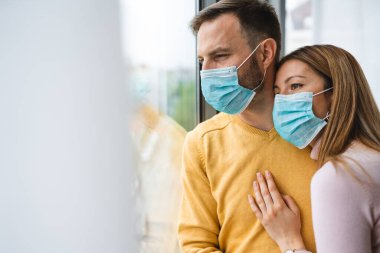 Koronavirüs karantinası sırasında evde izolasyon. Yüz maskesi takan kadın ve erkek. Coronavirus koruma ve önleme. Evde kal.