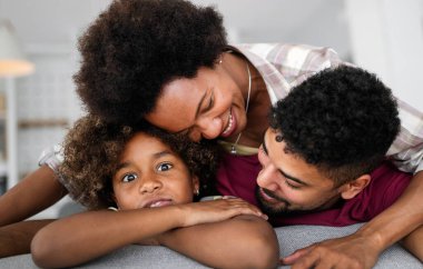 Mutlu siyah aile yatakta yatarken yatak odasında eğleniyor.