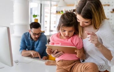 Tecrit ve çevrimiçi okul, teknoloji konsepti. Ebeveynler çocuklarına evde online ders çalışmaları için yardım ediyor.