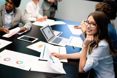 Bir grup iş arkadaşı sunum sırasında toplantı odasında.