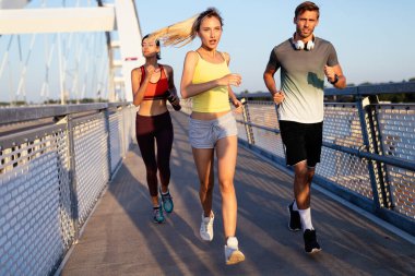 Sabah sporu. Köprüden koşarak geçen formda arkadaşlar. Sağlıklı yaşam tarzı.