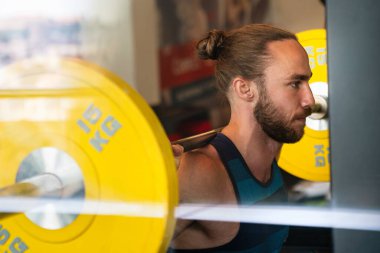 Spor salonunda makine üzerinde egzersiz yapan yakışıklı bir adam.